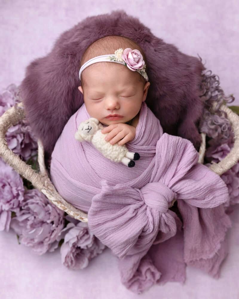 A newborn sleeping in a lavender wrap